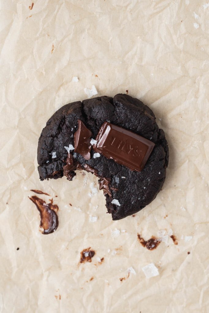 a bite out of a vegan double chocolate cookie with sea salt